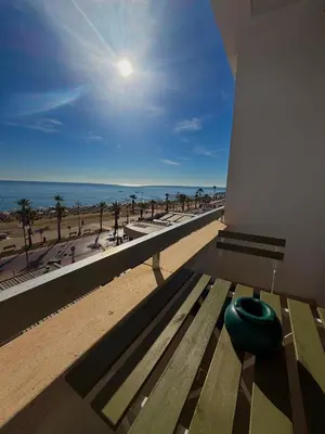 a bench on a building with a view of the beach at Golden Nest by the Sea in Larnaka