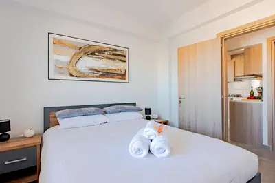 a bedroom with a white bed with towels on it at TelMar Sky View in Larnaka