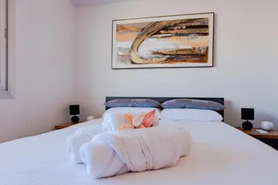 a bedroom with a white bed with towels on it at TelMar Sky View in Larnaka