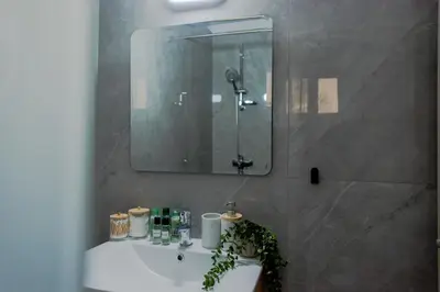 a bathroom sink with a mirror and a shower at TelMar Sky View in Larnaka