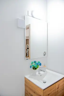 a bathroom with a white sink and a mirror at TelMar Sky View in Larnaka