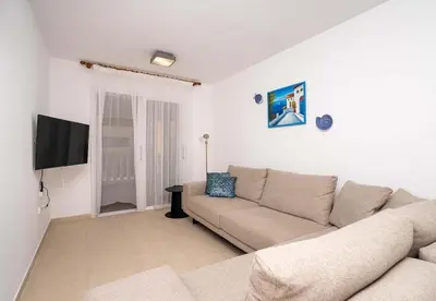 a living room with a couch and a flat screen tv at Stella's Little Island Gem in Paralimni