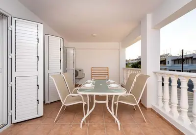 a dining room with a table and chairs on a balcony at Stella's Little Island Gem in Paralimni