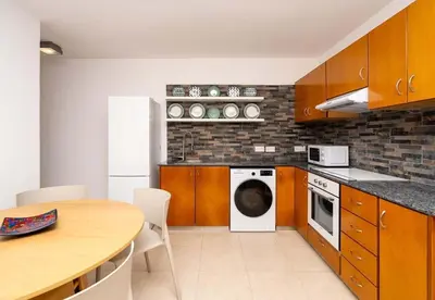 a kitchen with a table and a white dishwasher at Stella's Little Island Gem in Paralimni