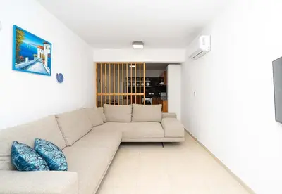 a living room with a white couch and blue pillows at Stella's Little Island Gem in Paralimni