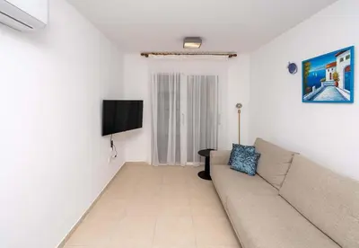 a living room with a couch and a flat screen tv at Stella's Little Island Gem in Paralimni