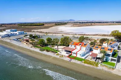 an aerial view of a beach with houses and the water at Wavestone Beachfront House in Meneou