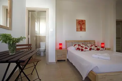 a bedroom with a bed and a table and a bathroom at Villa Elise in Protaras