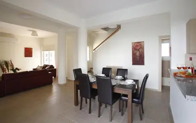 a dining room and living room with a table and chairs at Villa Elise in Protaras