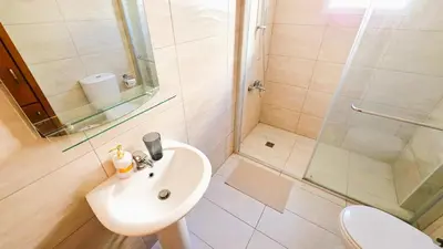 a bathroom with a sink and a shower at Sunny 2BR Getaway Steps from the Beach with Wi-Fi in Larnaka