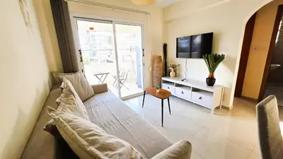 a living room with a couch and a tv at Sunny 2BR Getaway Steps from the Beach with Wi-Fi in Larnaka