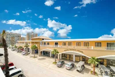 a large building with cars parked in a parking lot at Modern Smart-Home Studio Pools Gym Terrace View in Paralimni