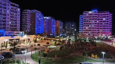 a park with a playground at night with tall buildings at Modern Smart-Home Studio Pools Gym Terrace View in Paralimni