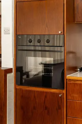 a oven in a wooden cabinet in a kitchen at 3 bedroom flat central, beach, walking streets in Limassol