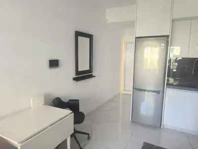 a white room with a desk and a mirror at Lux studio apartment in Limassol