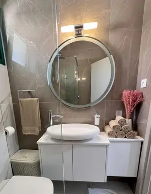 a bathroom with a white sink and a mirror at Luxury Beach Villa 2 min Walk to Sea & Airport in Meneou