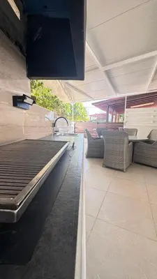 a kitchen with a sink and a patio with couches at Luxury Beach Villa 2 min Walk to Sea & Airport in Meneou