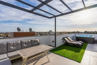 a patio with a couch and a table on a roof at Casino & Mall Luxury Jacuzzi Penthouse Suite in Limassol