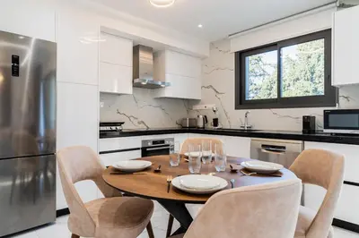 a kitchen with a wooden table and chairs in a kitchen at Casino & Mall Luxury Jacuzzi Penthouse Suite in Limassol