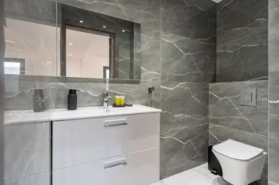 a bathroom with a white sink and a mirror at Casino & Mall Luxury Jacuzzi Penthouse Suite in Limassol