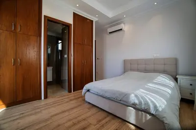 a bedroom with a bed and wooden cabinets at Cyprus Sunbay Retreat in Ayia Napa