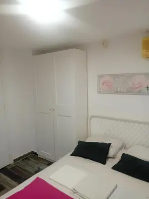 a bedroom with a white bed and a white cabinet at Smart 2 Bedroom Flat in Larnaka
