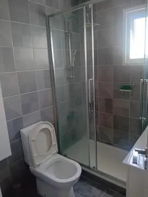 a bathroom with a toilet and a glass shower at Smart 2 Bedroom Flat in Larnaka