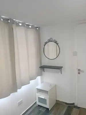 a white bathroom with a mirror and a table at Smart 2 Bedroom Flat in Larnaka