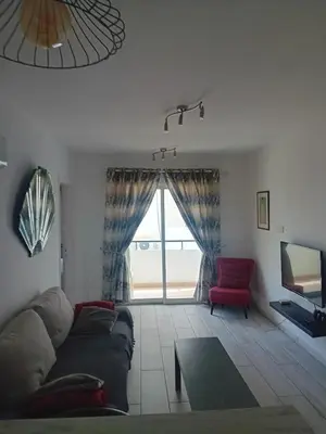 a living room with a couch and a red chair at Smart 2 Bedroom Flat in Larnaka