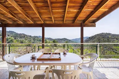a white table and chairs on a balcony with a view at Mountain Retreat in Kyperounda