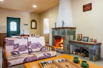 a living room with a couch and a fireplace at Mountain Retreat in Kyperounda