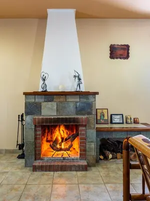 a stone fireplace in a living room at Mountain Retreat in Kyperounda