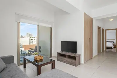 a living room with a couch and a flat screen tv at Downtown City View 2 Bedroom Apartment in Larnaka
