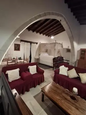 a living room with two red couches and an archway at Οίκος Λόφου-oikos Lofou in Lofou