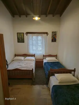 a bedroom with two beds and a window at Οίκος Λόφου-oikos Lofou in Lofou