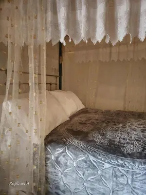 a bedroom with a bed with curtains on it at Οίκος Λόφου-oikos Lofou in Lofou