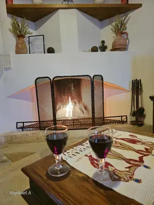 two glasses of wine on a table in front of a fireplace at Οίκος Λόφου-oikos Lofou in Lofou