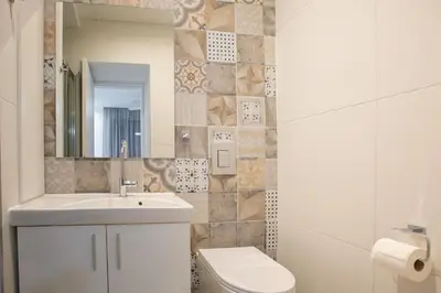 a bathroom with a sink and a toilet and a mirror at Two Bedroom House In Town Center by Sweet Keys in Limassol