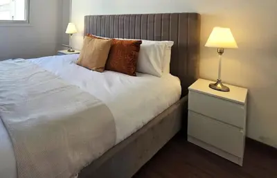 a bedroom with a bed with two lamps and a nightstand at City Heart Residence by Staycom in Nicosia