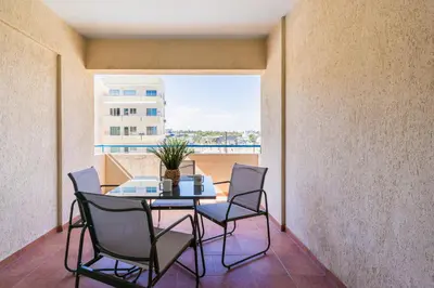 a table and chairs on a balcony with a view at Calina - 3BR Apt W Pool & Balcony in Mackenzie in Larnaka