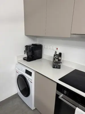 a kitchen with a microwave and a washing machine at Modern Marvel Seaview in Paralimni