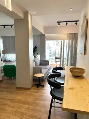 a living room with a couch and a table and chairs at Zeus Downtown Hub with Panoramic View in Nicosia