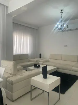 a living room with white furniture and a chandelier at Famagusta Guest House in Mağusa