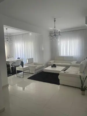 a living room with white furniture and a dining room at Famagusta Guest House in Mağusa