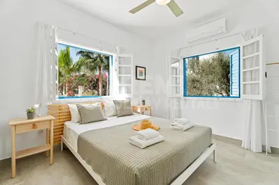 a white bedroom with two beds and a window at Apartment Ino in Protaras