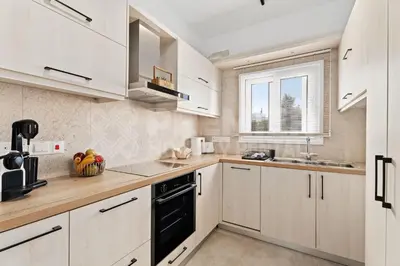 a kitchen with white cabinets and a black dishwasher at Apartment Ino in Protaras