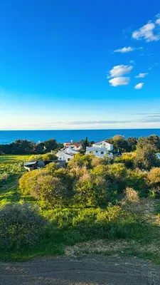 a group of houses in a field near the ocean at Centrally located studio with Mountain & Sea views in Avdhelleron