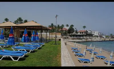a row of lounge chairs and umbrellas on a beach at Centrally located studio with Mountain & Sea views in Avdhelleron
