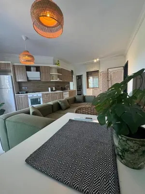 a living room with a couch and a table at Kıbrıs Girnede 1 yatak odalı Süper lüks havuzlu daire in Vuda