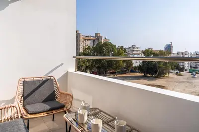 a balcony with a chair and a table and a window at Sonic 2-Bedroom Apartment in Larnaka